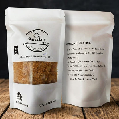 Two packages of Aneela's Kheer Mix on a wooden surface with a dark background