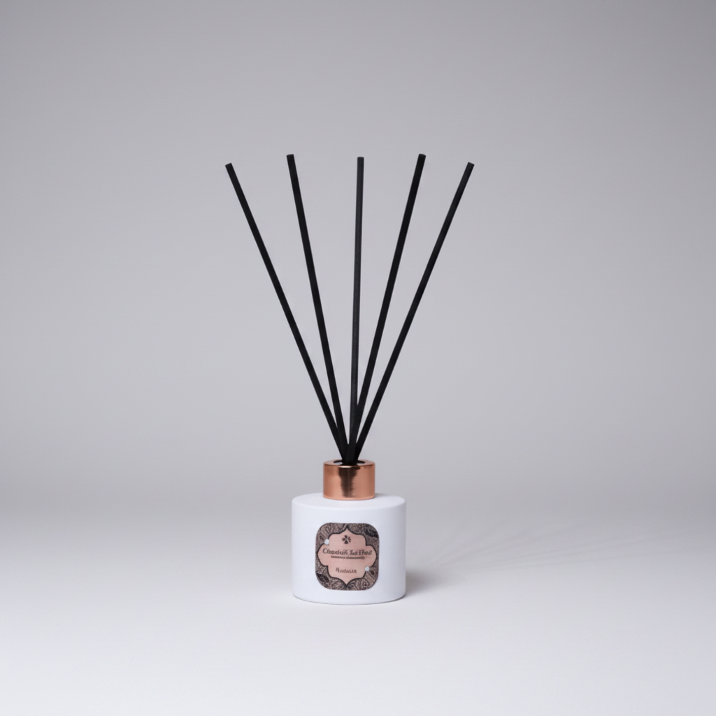 Reed diffuser with black sticks on a white base against a textured gray background
