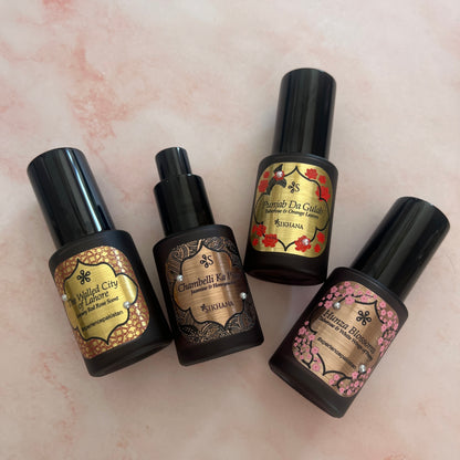 Four Sikhana Luxury Body Mists on pink marble