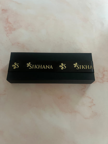 Closed black Sikhana perfume gift box with gold-branded ribbon