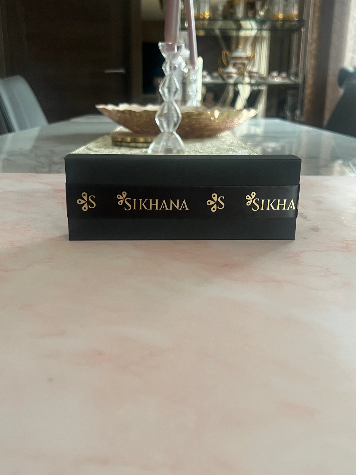 Three open gold heart-shaped jars showing the solid perfume inside the black presentation box