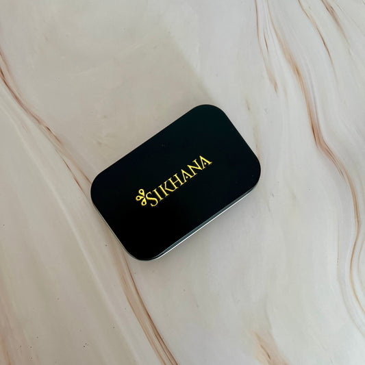 Black scent case with 'Sikhana' branding on a marble surface