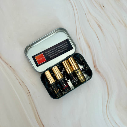 Set of small bottles with gold caps in a black case on a marble surface
