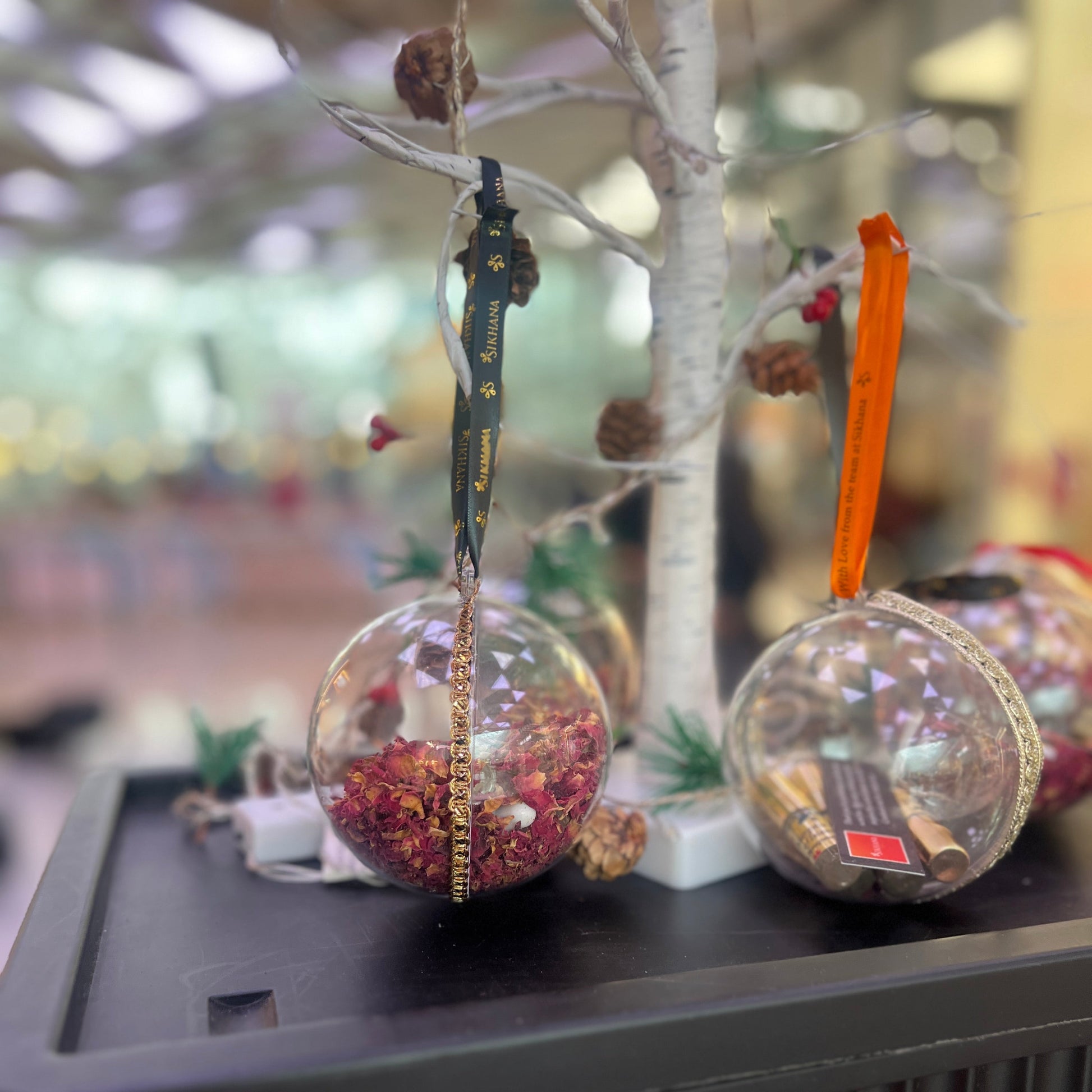 Decorative glass ornaments with red and gold elements on a blurred background