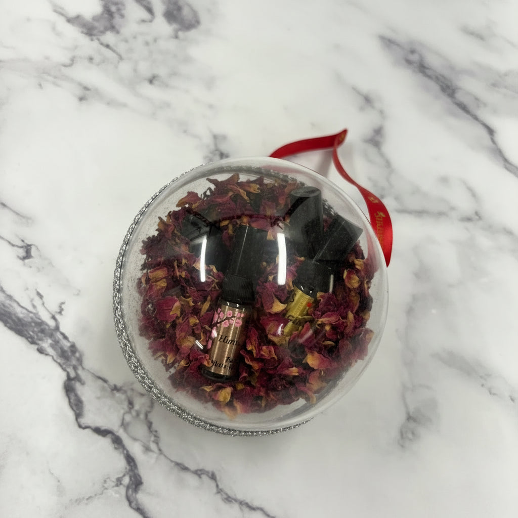 Clear jar with dried flowers and a red ribbon on a marble surface