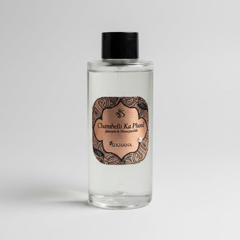Small bottle with decorative label on a reflective surface