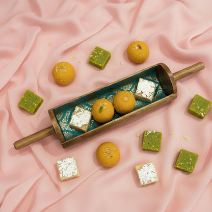 Decorative rolling pin with blue and gold pattern on a metallic surface
