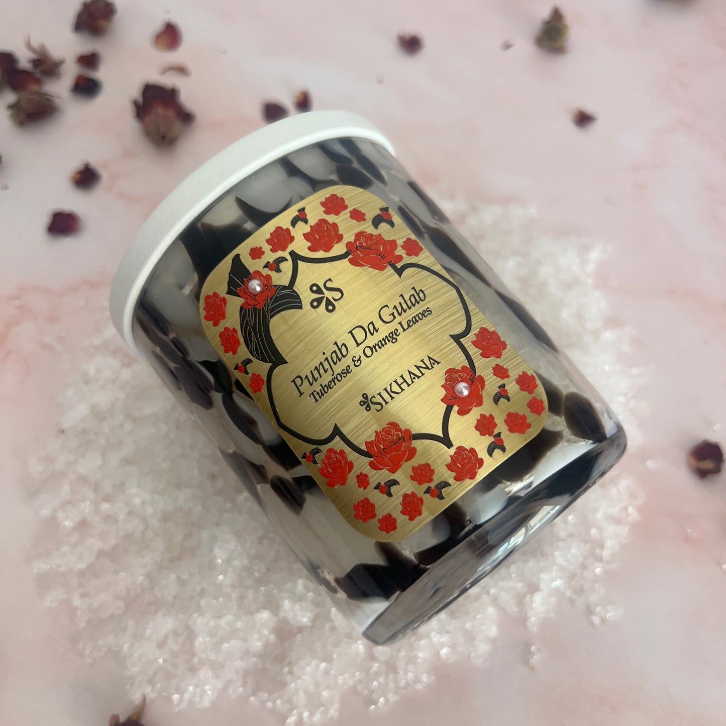 Small container with a decorative label on a textured surface
