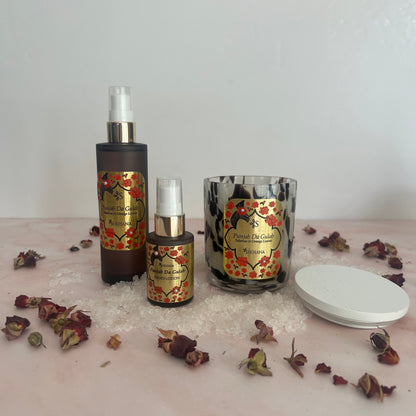 Two decorative bottles with floral designs on a white surface with dried flowers.