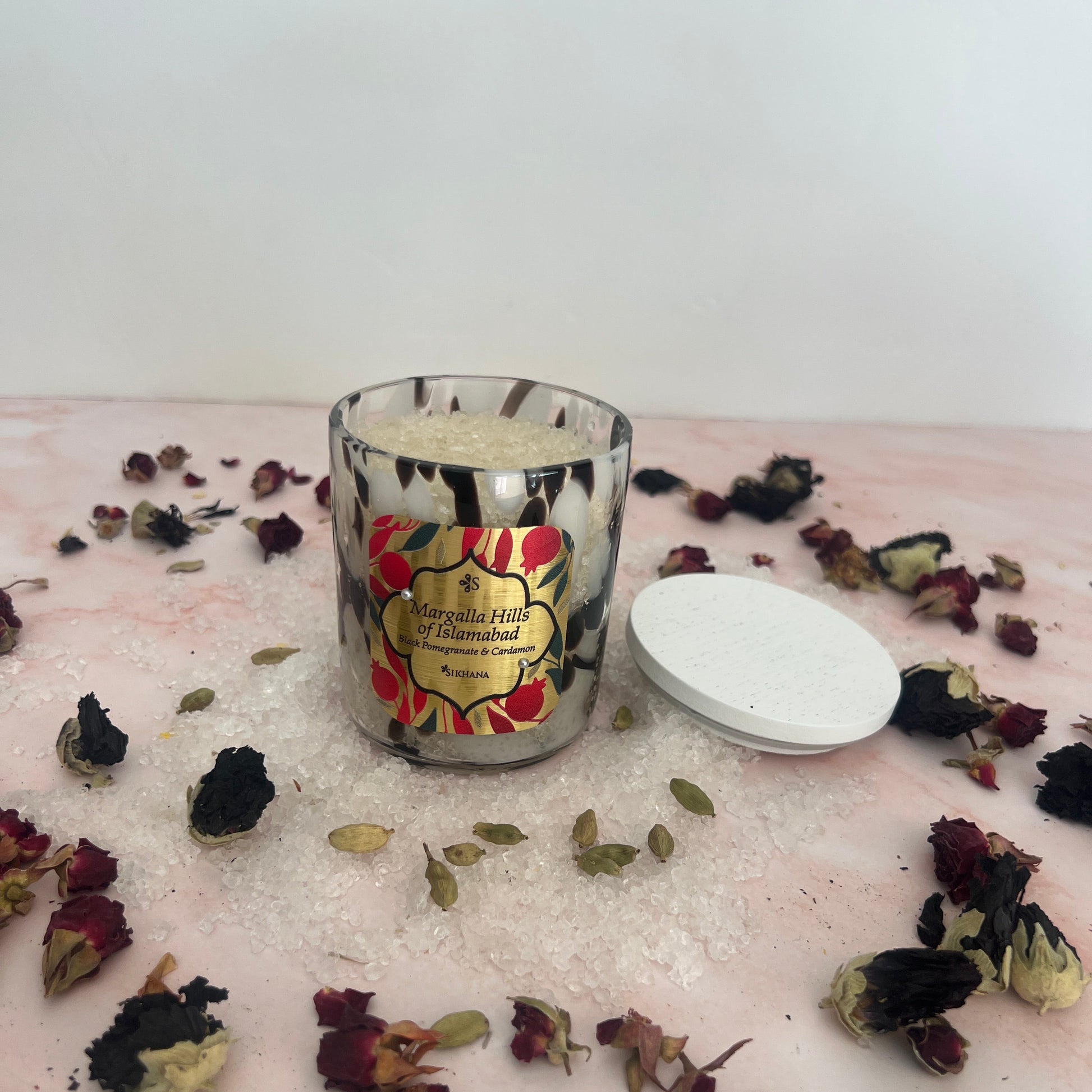 Bath Salts with floral design surrounded by dried flowers on a textured surface