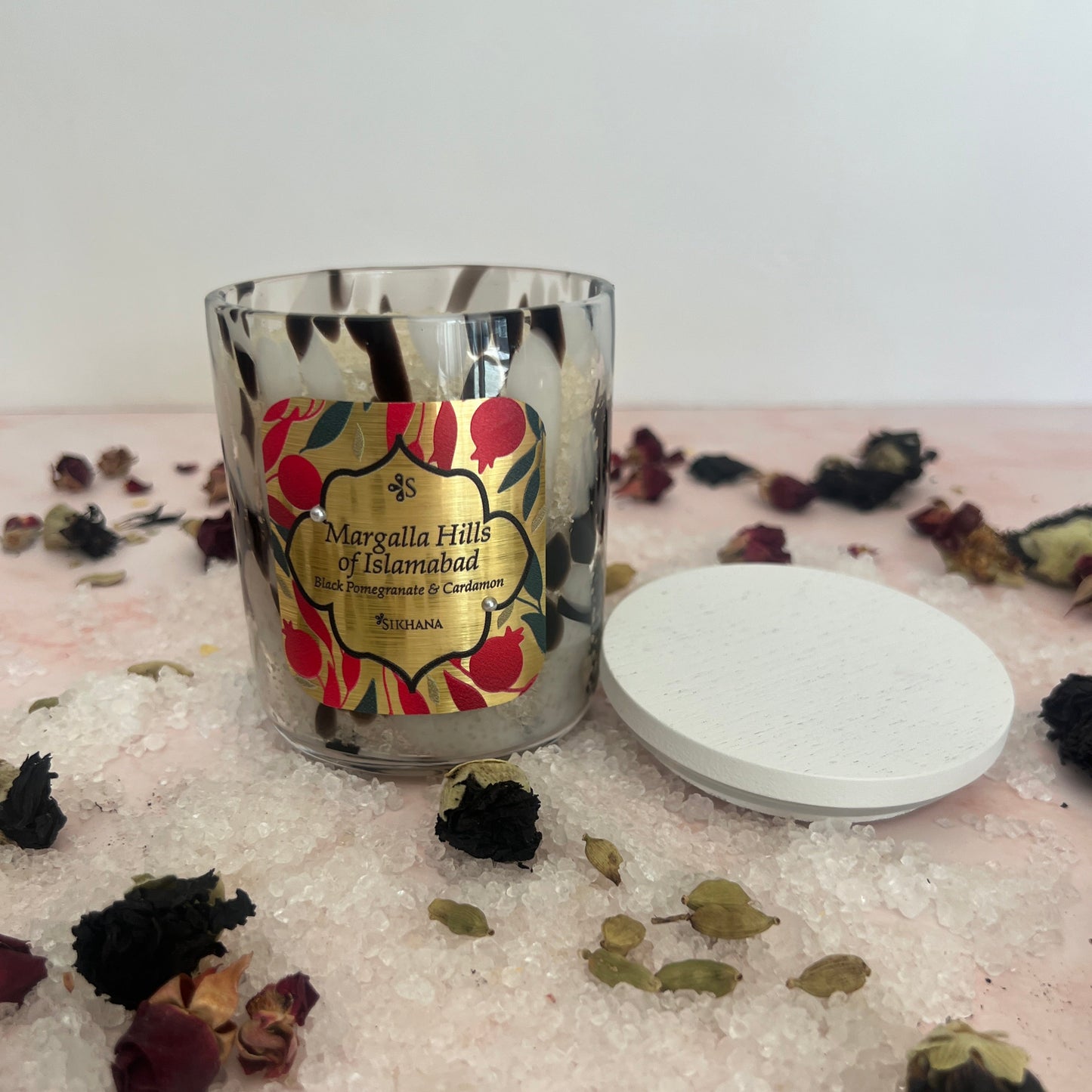 Bath Salts with floral design on a white surface with dried flowers and leaves.