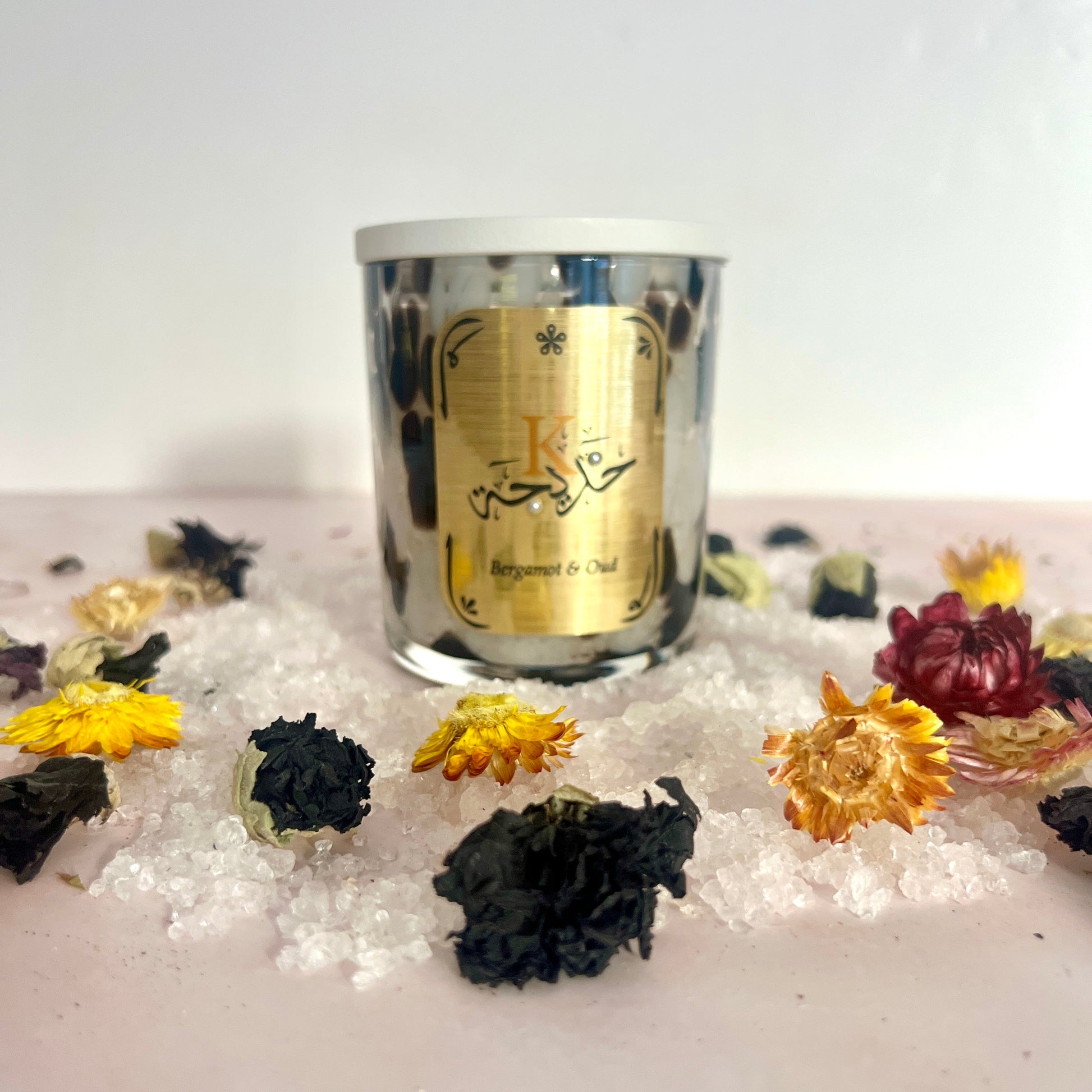 Bath Salts with a gold label surrounded by decorative flowers on a white surface