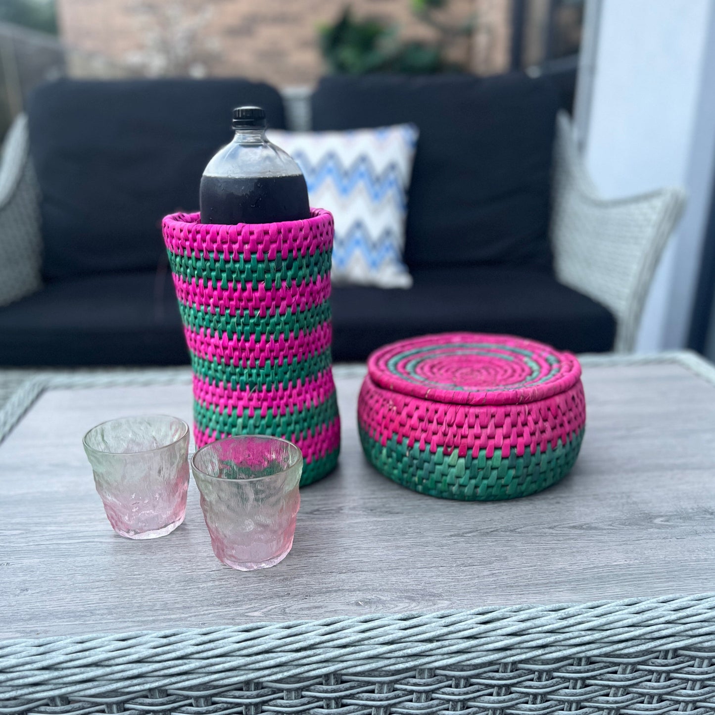 pink and green hot pot and bottle holder made by artisans from date palm leaves