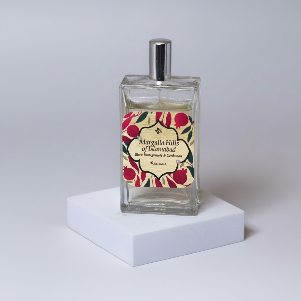 Perfume bottle with a pomegranate and cardamom theme on a neutral background